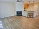 Open-concept living room with fireplace, wood floors and breakfast bar to kitchen at 4206 Camden Woods Ct, Raleigh, NC 27612