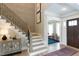 Welcoming foyer with hardwood floors, decorative console table, staircase, and views into other living spaces at 45 Little Gem Ln, Fuquay Varina, NC 27526