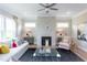 Cozy living room with a fireplace, hardwood floors, a comfortable seating arrangement, and bright natural light at 45 Little Gem Ln, Fuquay Varina, NC 27526