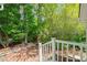 Brick patio with white railing overlooking a landscaped backyard with mature trees at 4500 Lancashire Dr, Raleigh, NC 27613