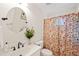 Bathroom featuring a round mirror, floral shower curtain, white toilet and vanity, and matte black hardware at 4500 Lancashire Dr, Raleigh, NC 27613