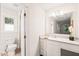 Bathroom with white cabinets and large mirror above the vanity and open doorway to shower at 4500 Lancashire Dr, Raleigh, NC 27613