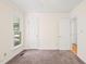 Bedroom featuring carpet, light walls, two white doors, and a window allowing for ample natural light at 4500 Lancashire Dr, Raleigh, NC 27613
