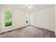 Bedroom with carpet, light walls, ceiling fan, white doors, and two windows providing natural light at 4500 Lancashire Dr, Raleigh, NC 27613