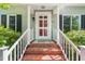 Eye-level image of the home's front door featuring painted white trim and red-brick stair case at 4500 Lancashire Dr, Raleigh, NC 27613