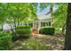 Charming home exterior featuring a red-brick staircase with bright red door and mature trees at 4500 Lancashire Dr, Raleigh, NC 27613