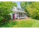 Back of house featuring a screened porch and a red door for easy access to the yard at 4500 Lancashire Dr, Raleigh, NC 27613