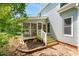 Home has a screened porch with stairs leading to a red brick patio in the backyard at 4500 Lancashire Dr, Raleigh, NC 27613