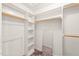 Bright walk-in closet with white shelving, clothing rods, and a full-length mirror at 4500 Lancashire Dr, Raleigh, NC 27613