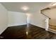 Spacious living room featuring sleek dark hardwood floors and stairway access to the upper level at 4716 Princess Lita Way, Raleigh, NC 27610