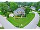 Expansive aerial view showcases a meticulously landscaped home with lush green lawn, trees, and inviting curb appeal at 4953 Mashpee Ln, Apex, NC 27539