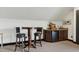A table, chairs and counter with cabinets and small refrigerator create a functional in-home bar area at 4953 Mashpee Ln, Apex, NC 27539