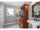 Bathroom featuring dual pedestal sinks, decorative cabinet, and bright natural lighting at 4953 Mashpee Ln, Apex, NC 27539