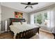 Inviting bedroom with hardwood floors, a ceiling fan, and a window with sheer curtains at 4953 Mashpee Ln, Apex, NC 27539