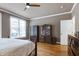 Bedroom features hardwood floors, ceiling fan, and large window with natural light at 4953 Mashpee Ln, Apex, NC 27539