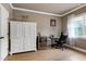 Cozy bedroom with a large white armoire, wine cooler, and a view from a bright window at 4953 Mashpee Ln, Apex, NC 27539