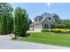Well-manicured front yard with flower beds, and a brick and siding home with a three-car garage at 4953 Mashpee Ln, Apex, NC 27539