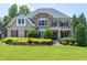 Stately two-story home with stone accents, manicured lawn, and mature landscaping at 4953 Mashpee Ln, Apex, NC 27539