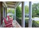 Inviting front porch with red rocking chairs and views of the lush landscaping at 4953 Mashpee Ln, Apex, NC 27539