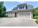 Three car garage with solar panels on roof and neutral color siding and dark shutters at 4953 Mashpee Ln, Apex, NC 27539