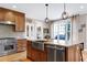 The chef's kitchen has a stainless steel sink, range, and island with modern lighting at 4953 Mashpee Ln, Apex, NC 27539