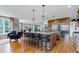 Open kitchen with island seating, granite countertops, stainless appliances, and hardwood floors at 4953 Mashpee Ln, Apex, NC 27539