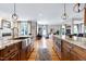 Large kitchen featuring island with stainless sink and oven, granite countertops and hardwood floors at 4953 Mashpee Ln, Apex, NC 27539