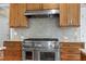 Close-up of a stainless steel range oven with granite countertop and tiled backsplash at 4953 Mashpee Ln, Apex, NC 27539