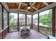 Covered and screened-in back porch with wood floors, a ceiling fan, and furniture for outdoor relaxation at 4953 Mashpee Ln, Apex, NC 27539
