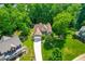 Aerial view of the home nestled among mature trees, featuring a long driveway and well-manicured lawn at 509 Fish Pond Ct, Rolesville, NC 27571