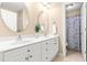 Bathroom featuring double sinks, a large mirror, and a shower with a patterned curtain at 509 Fish Pond Ct, Rolesville, NC 27571