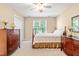 Carpeted bedroom featuring a four-poster bed, wooden dressers, and a ceiling fan at 509 Fish Pond Ct, Rolesville, NC 27571