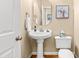 Stylish powder room with pedestal sink and modern toilet at 509 Fish Pond Ct, Rolesville, NC 27571