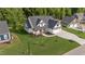An aerial view of a home that features an attached three-car garage and lush landscaping at 525 Allesandra Dr, Clayton, NC 27527