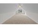 Carpeted attic space illuminated by a ceiling fan and natural light from a window at 525 Allesandra Dr, Clayton, NC 27527