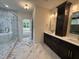 Spacious bathroom with marble-look tile, double vanity, and seamless access to the shower area at 525 Allesandra Dr, Clayton, NC 27527