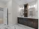 Bathroom vanity with dual sinks, mirrors and dark wood cabinets against marble floors at 525 Allesandra Dr, Clayton, NC 27527