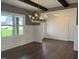 Elegant dining room with dark hardwood floors, stylish chandelier, and white wainscoting at 525 Allesandra Dr, Clayton, NC 27527