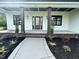 Inviting front porch featuring craftsman style columns and meticulously landscaped front yard at 525 Allesandra Dr, Clayton, NC 27527