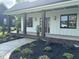 Inviting front porch featuring craftsman style columns and meticulously landscaped front yard at 525 Allesandra Dr, Clayton, NC 27527