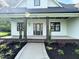 Inviting front porch featuring craftsman style columns and meticulously landscaped front yard at 525 Allesandra Dr, Clayton, NC 27527