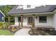 Inviting front porch with dark wood pillars, a brick base and new landscaping at 525 Allesandra Dr, Clayton, NC 27527