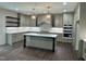 Spacious kitchen featuring gray cabinets, marble backsplash, central island, and pendant lighting at 525 Allesandra Dr, Clayton, NC 27527