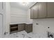 Well-lit laundry room featuring custom cabinets, a folding counter, and stylish marble flooring at 525 Allesandra Dr, Clayton, NC 27527