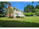 Charming home exterior showcasing a well-maintained lawn, deck, brick chimney and mature trees at 5401 Lower Creek Ct, Apex, NC 27539
