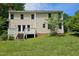 Spacious backyard view featuring a well-kept lawn, back of house and a small deck with access from multiple doors at 5401 Lower Creek Ct, Apex, NC 27539