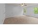Bright bedroom features neutral carpeting, a ceiling fan, and natural light from the large windows at 5401 Lower Creek Ct, Apex, NC 27539