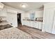 Open kitchen with stainless steel appliances, granite countertops, and white cabinets with updated flooring at 5401 Lower Creek Ct, Apex, NC 27539