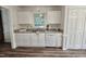 Bright kitchen features white cabinets, updated countertops and stainless steel sink beneath a window at 5401 Lower Creek Ct, Apex, NC 27539