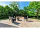 Backyard with a stone patio with comfortable outdoor seating and a firepit with manicured hedges and trees at 5404 Onyx Mill Ct, Raleigh, NC 27616